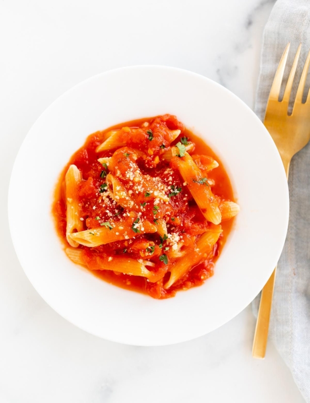 A plate of penne arrabbiata, topped with grated pecorino