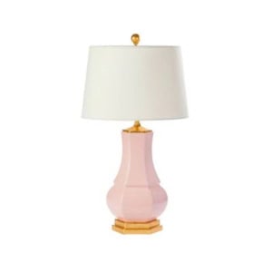 A pink ceramic table lamp with a gold base and finial, topped with a white fabric lampshade—perfect for nightstand decorating.