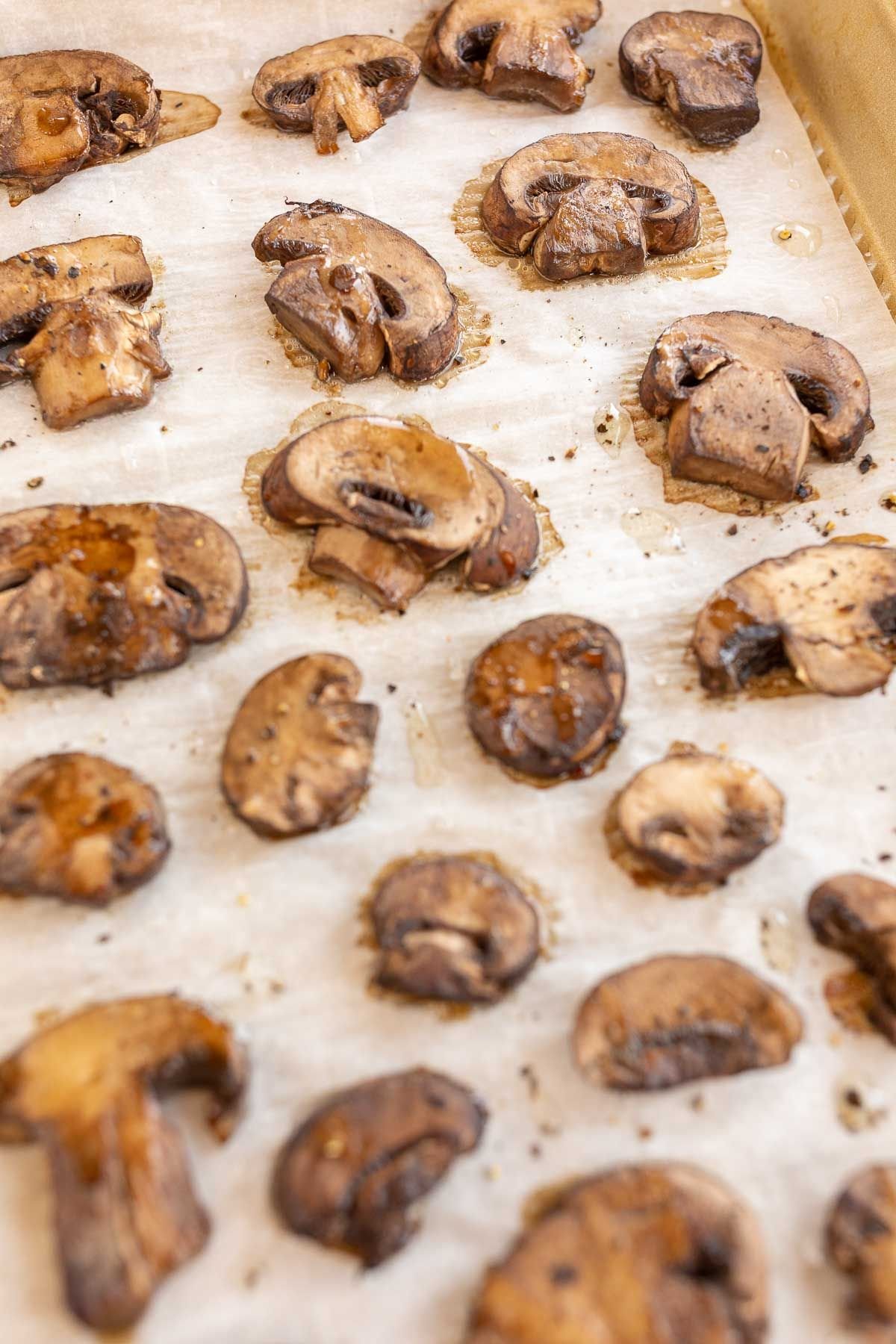 Roasted mushrooms on a sheet pan lined with parchment paper