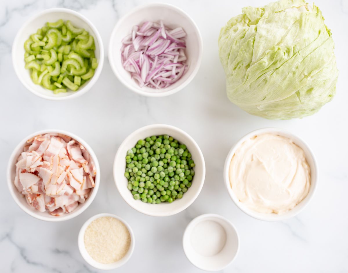 Ingredients for seven layer salad spread out on a marble surface.