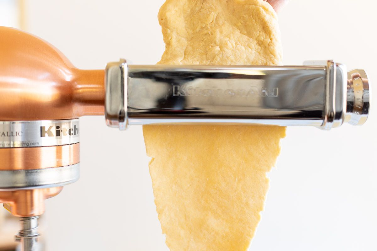 Pasta dough being passed through a pasta attachment