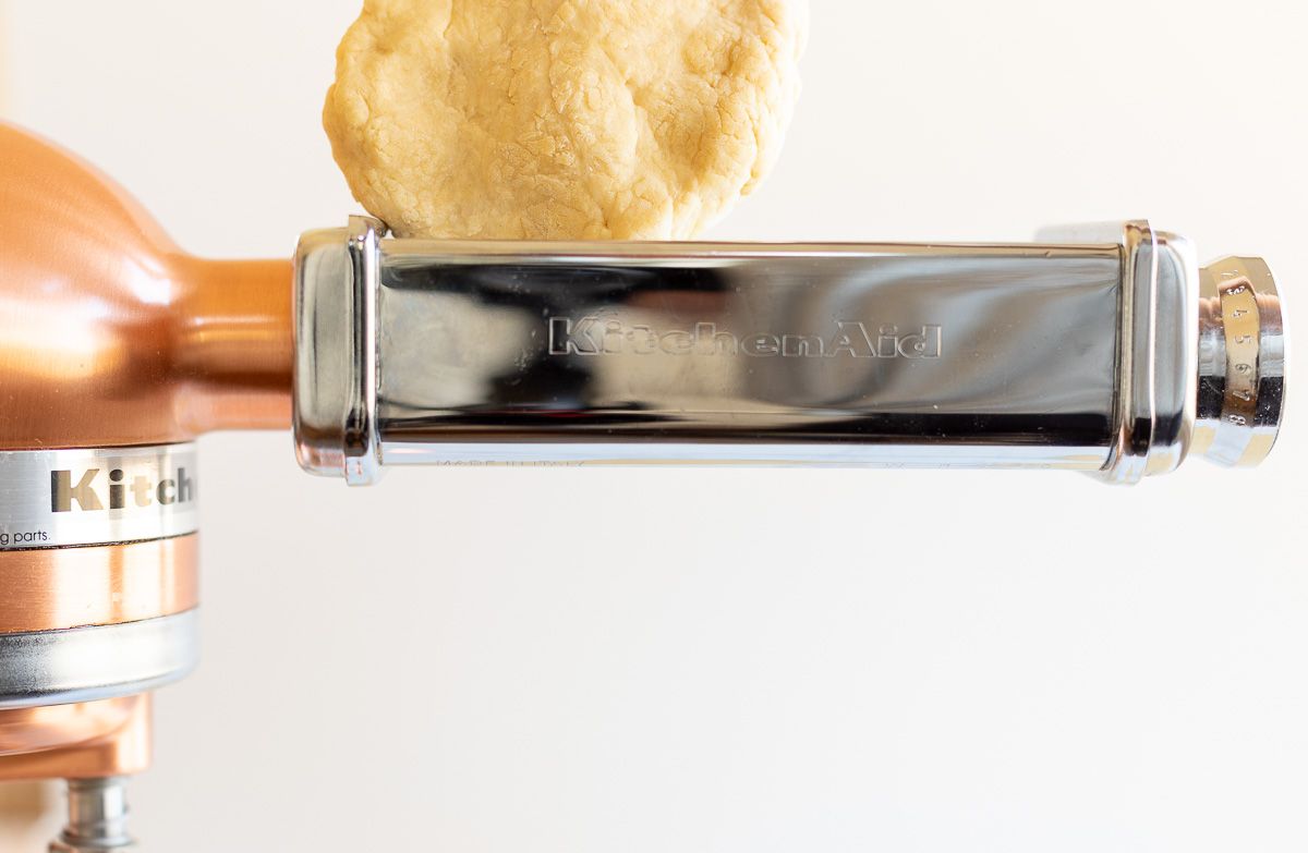 Pasta dough being passed through a pasta attachment