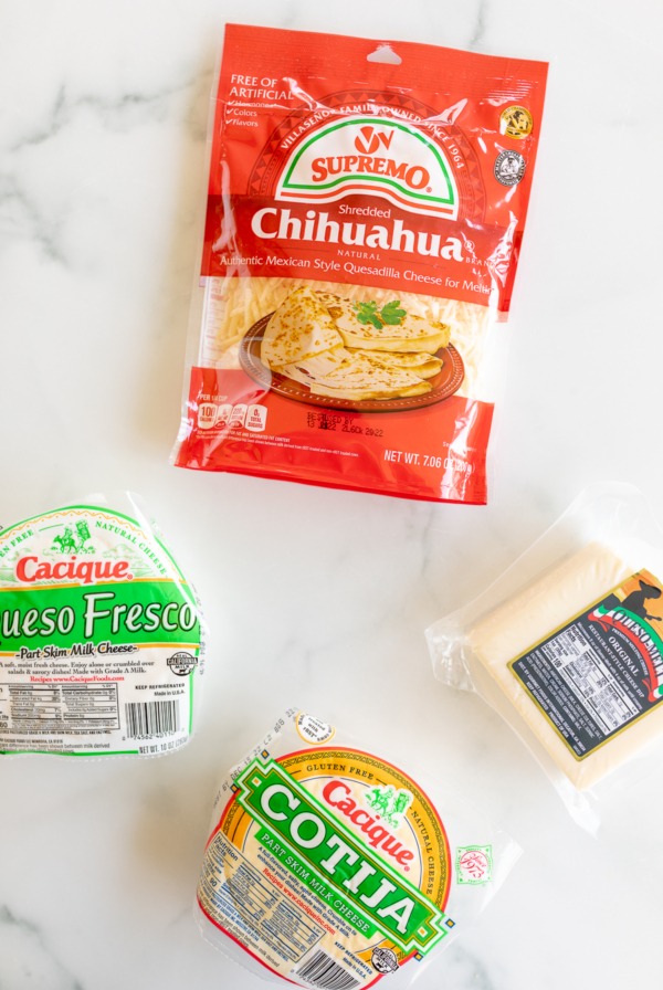 A variety of Mexican cheeses on a marble countertop, perfect for making the best tacos.