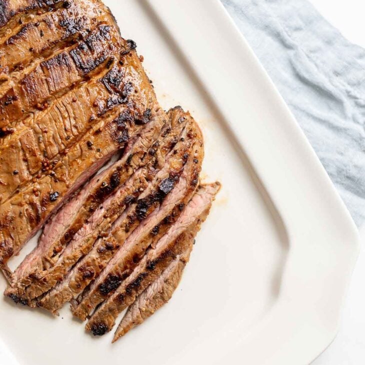 A white plate with sliced carne asada recipe