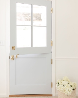 A dutch door painted in a coastal blue paint color, basket of flowers on the floor