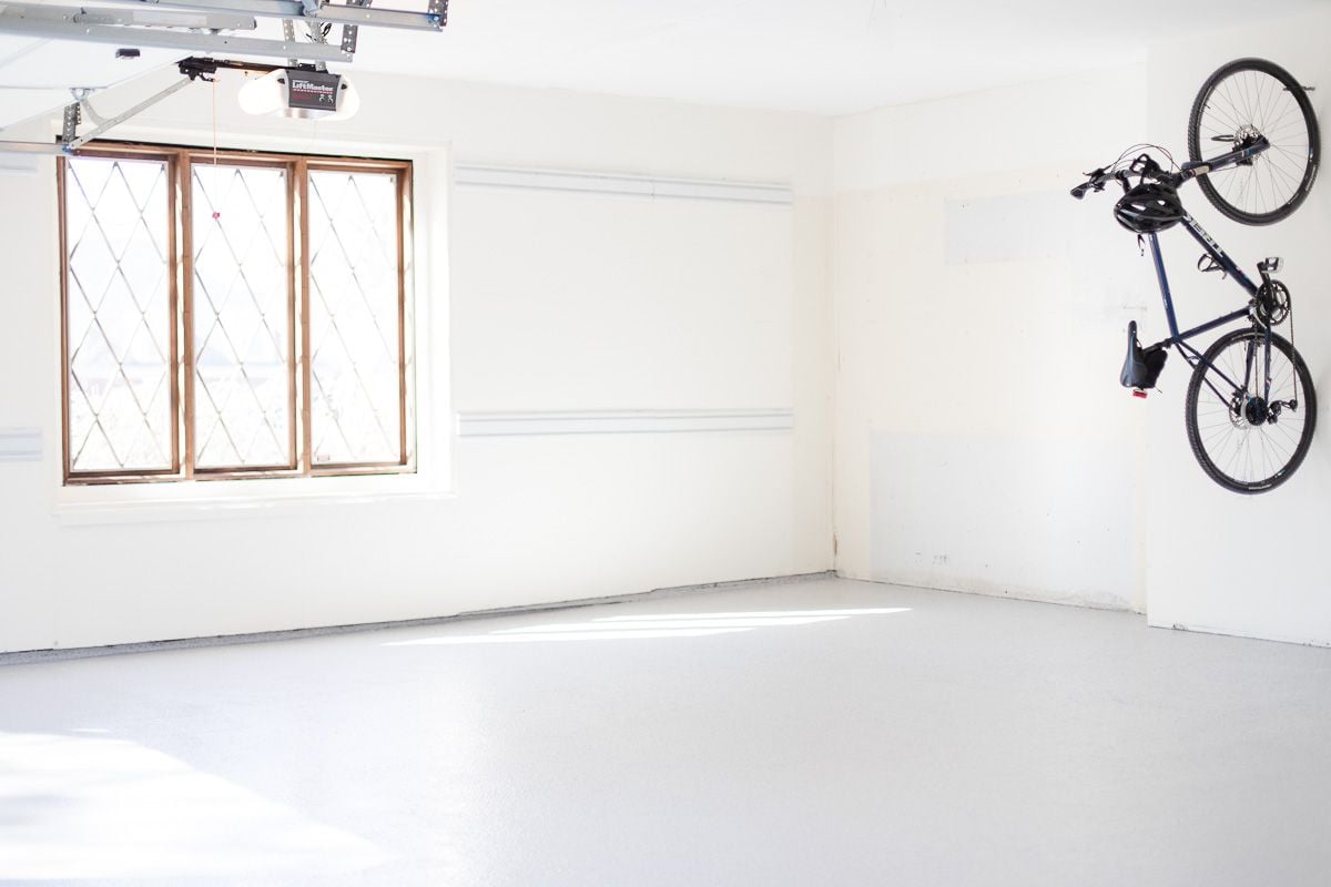 An empty garage with a diamond paned window on one wall