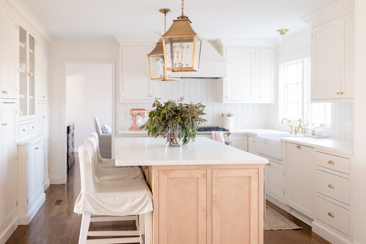 a white kitchen with a wood island protected with Modern Masters dead flat finish