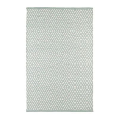a green and white patterned indoor outdoor rug