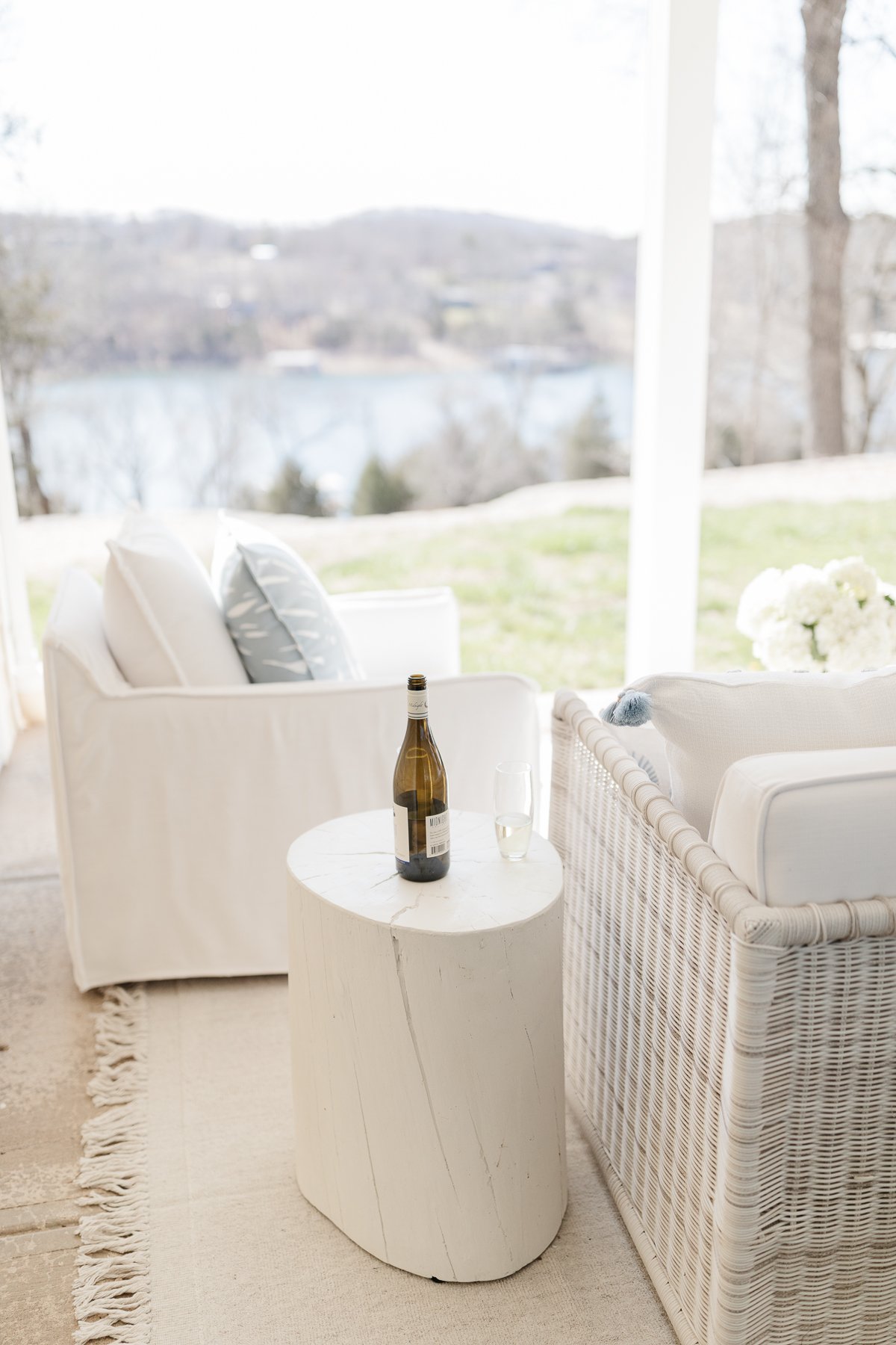 an outdoor patio with serena and lily furniture and a light colored indoor outdoor rug