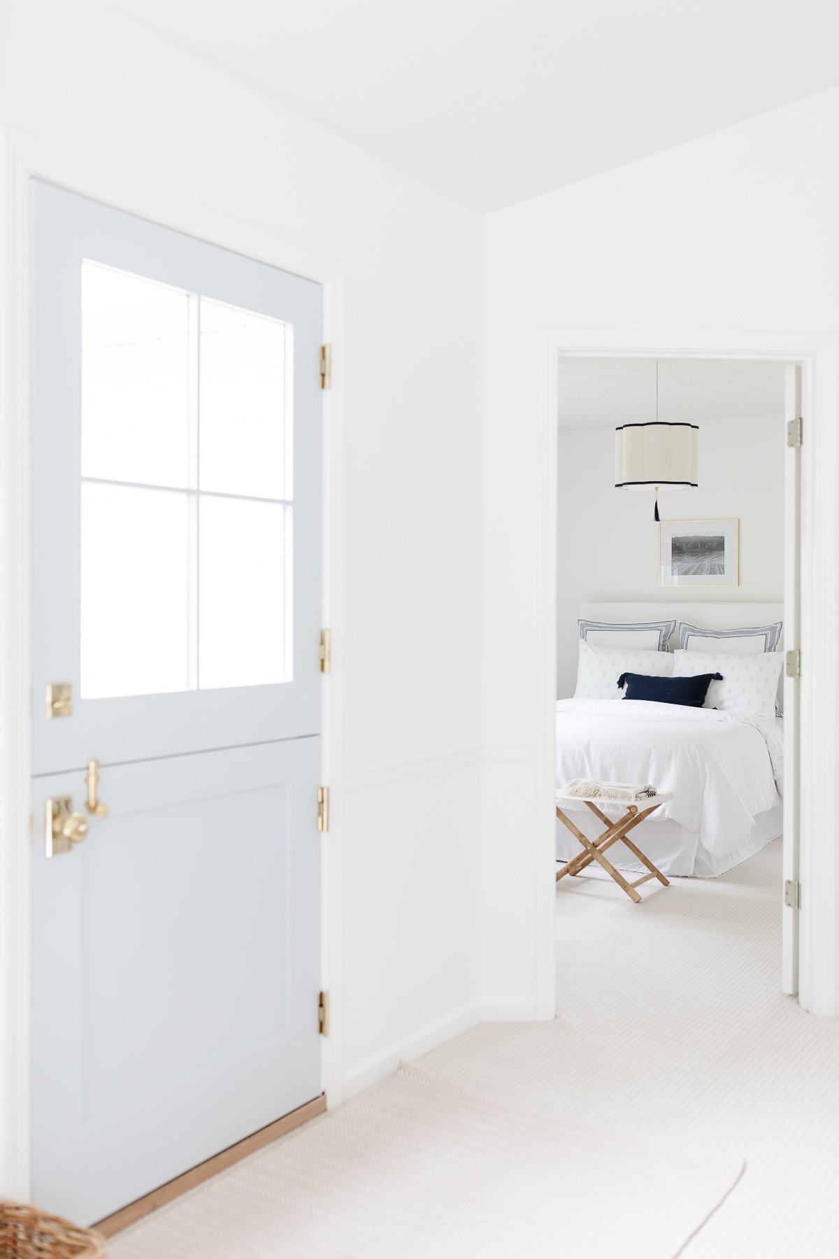 A soft blue dutch door with a neutral indoor outdoor rug in front.