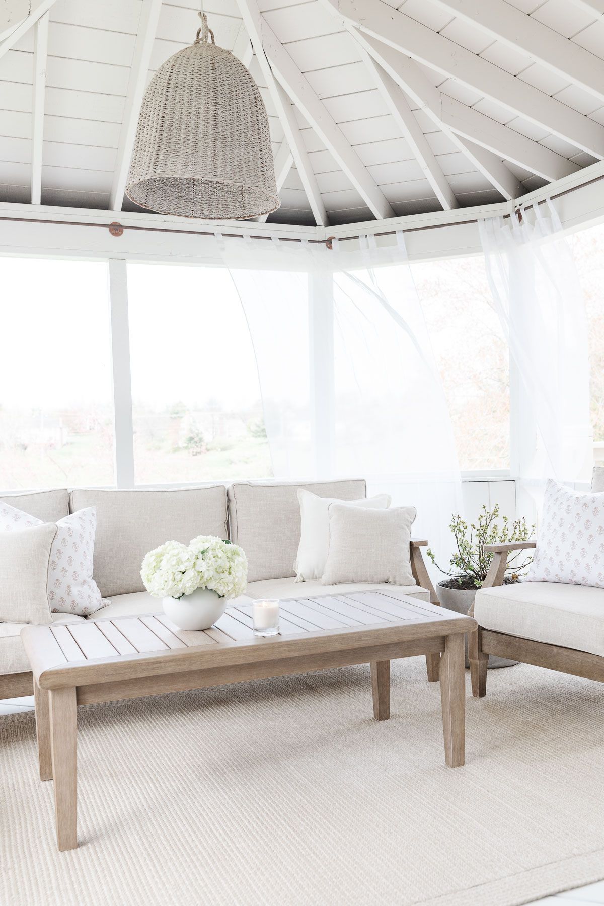 A screened in porch with a white interior, completed with a porch enclosure system