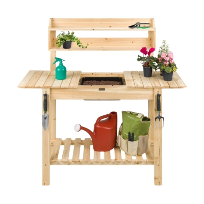 A potting bench made of wood with pots and a watering can.