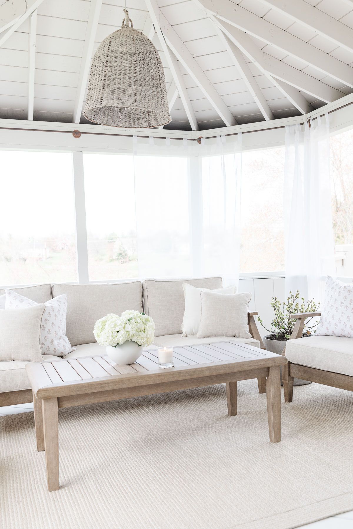 A white screened porch completed with a DIY screen porch kit.