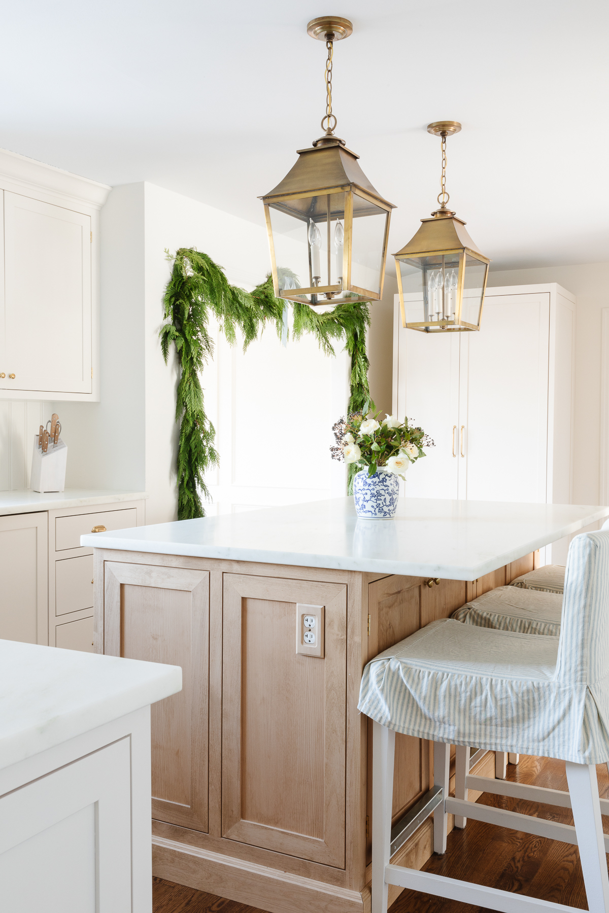 shaker inset cabinets and island with brass lanterns above