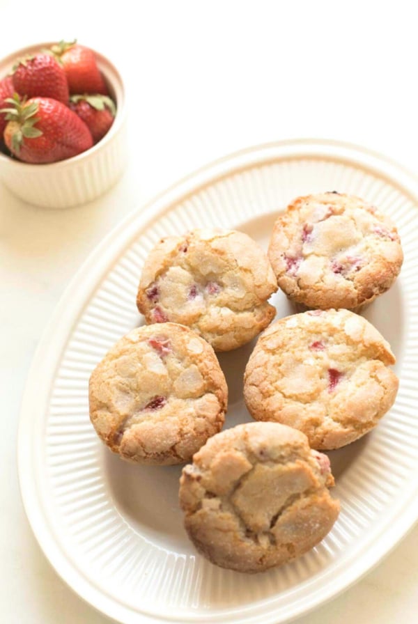 Strawberry recipes include strawberry muffins on a plate next to a bowl of strawberries.