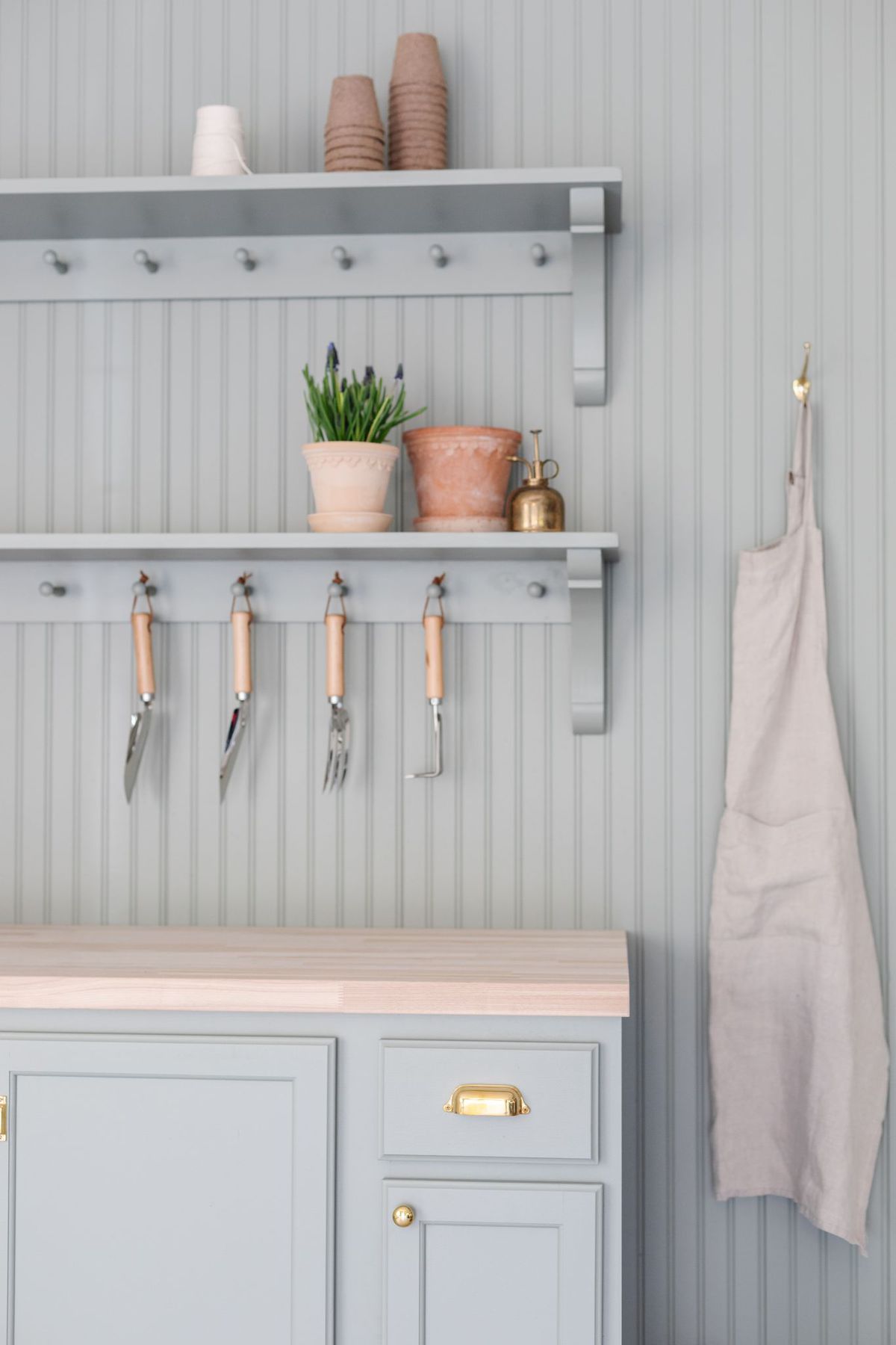 A green built in potting bench painted in Sherwin Williams Evergreen Fog