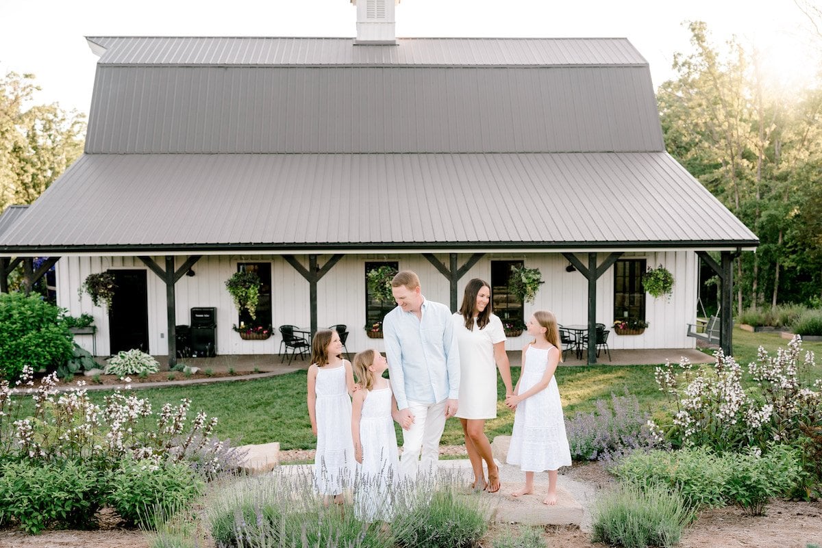 julie blanner and family in front of white farmhouse