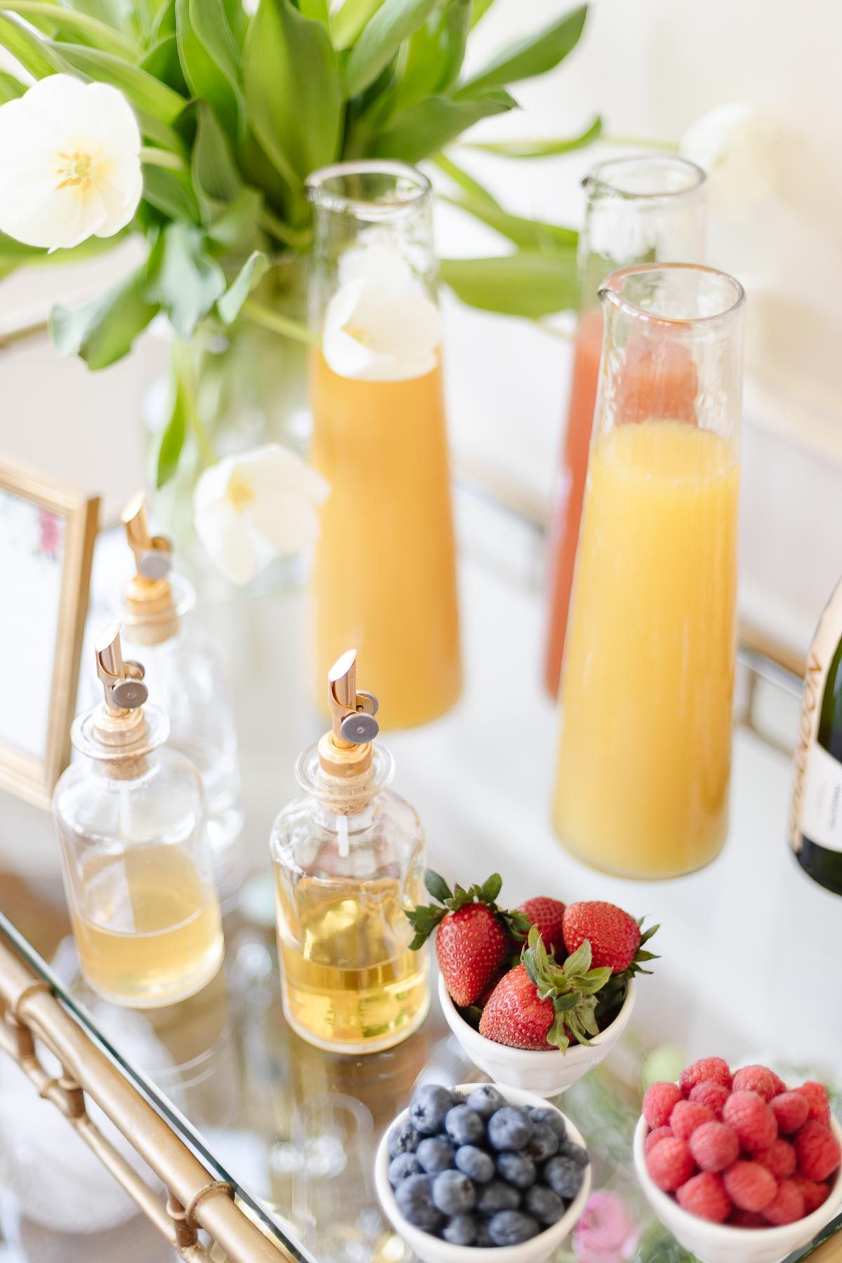 mimosa bar ideas with white tulips and fresh juices in glass bottles