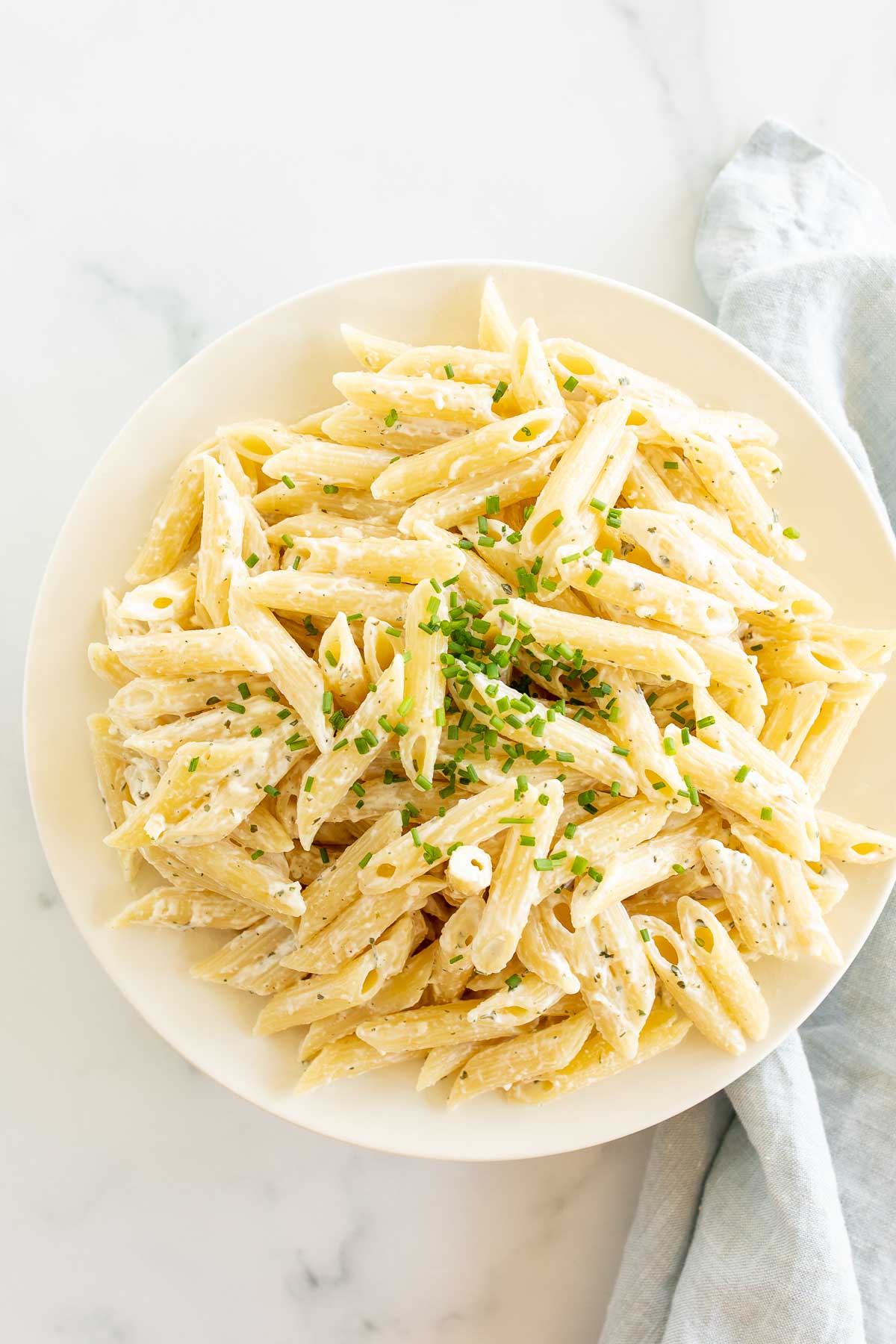 A white plate full of boursin pasta.