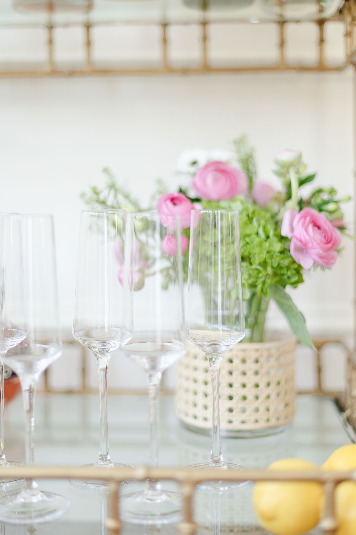 Empty champagne glasses and fresh flowers set up for a bubbly bar