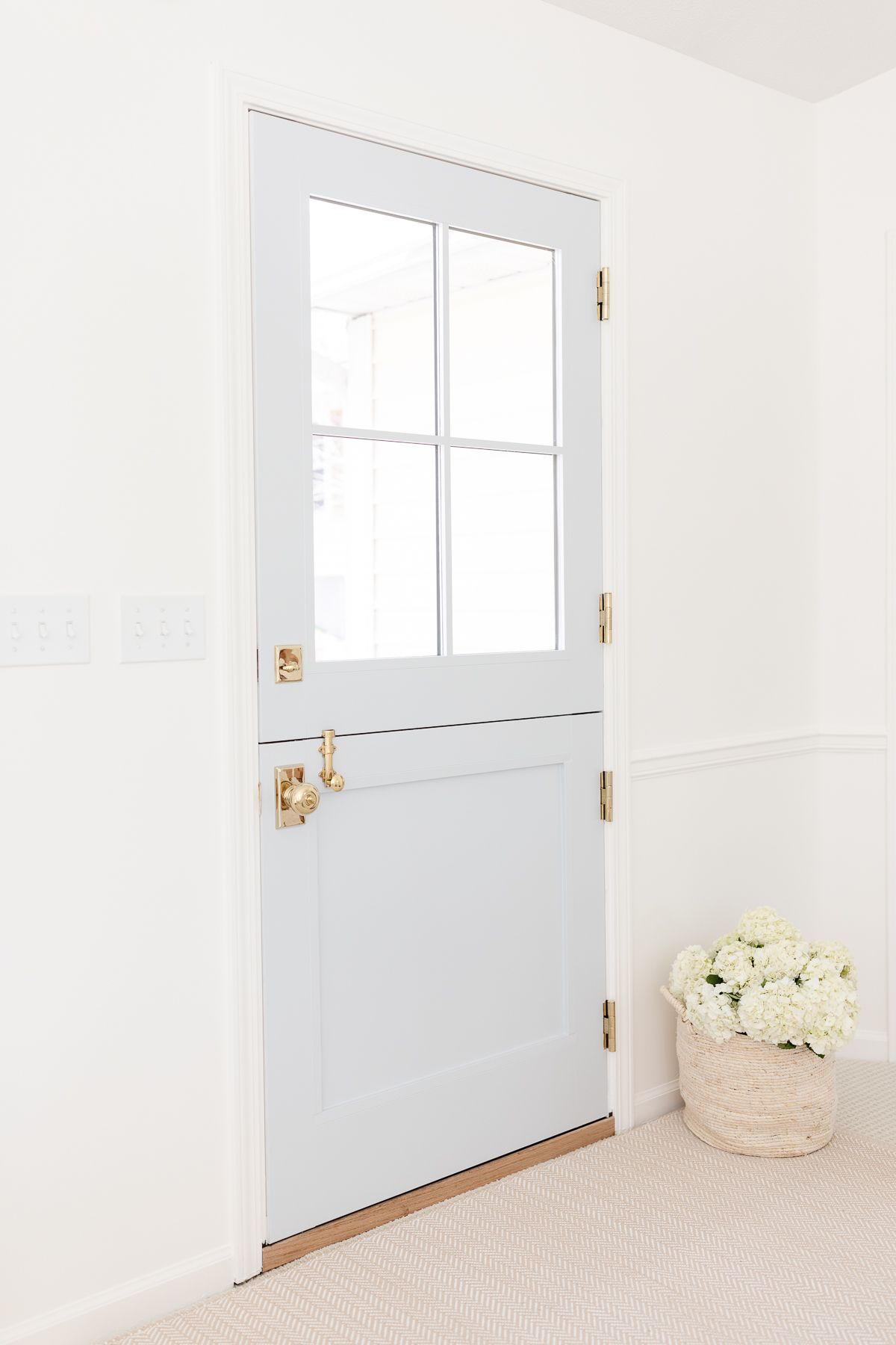 Brass dutch door hardware on a soft blue door