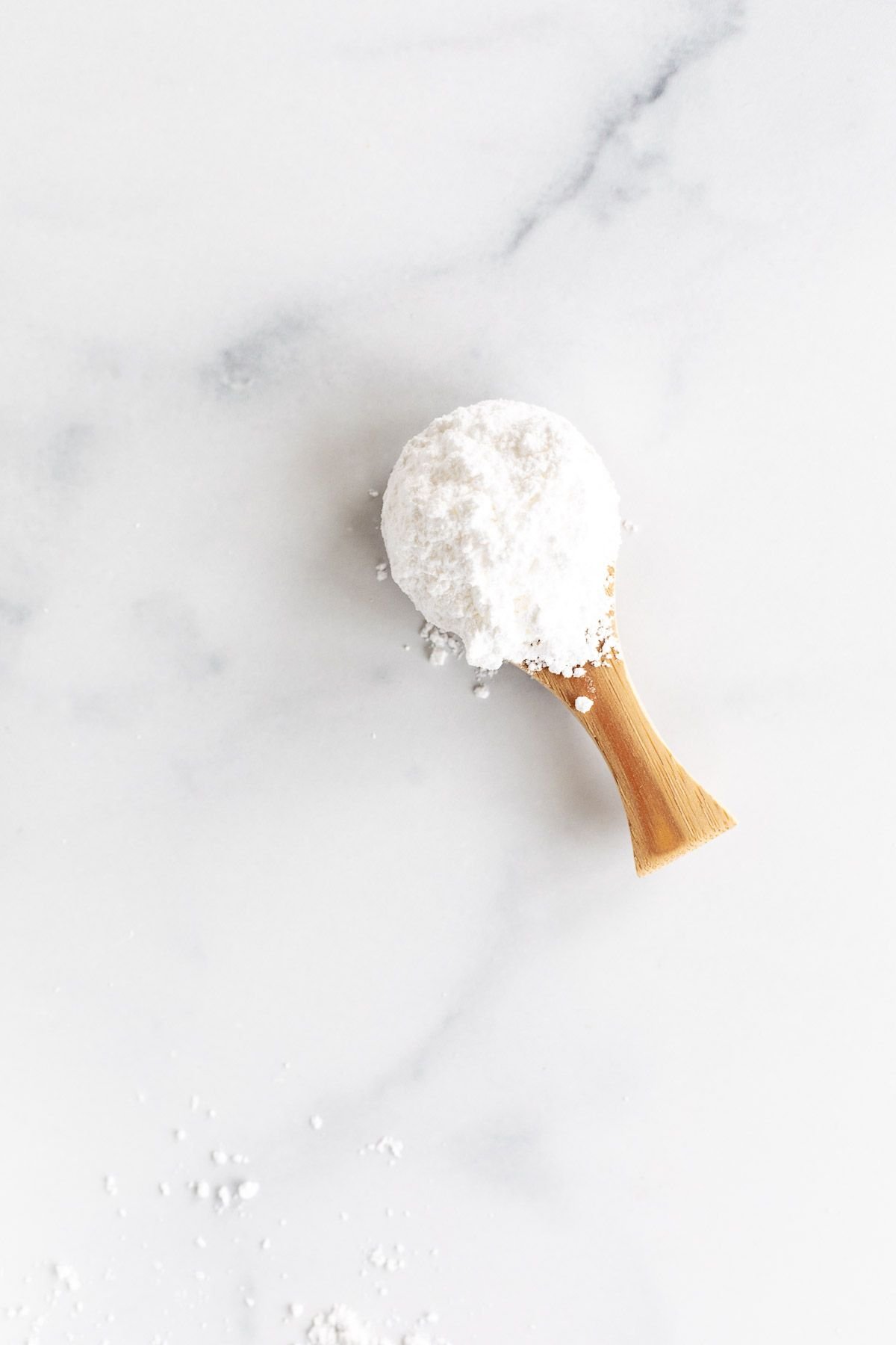 A small wooden spoon full of homemade confectioners sugar