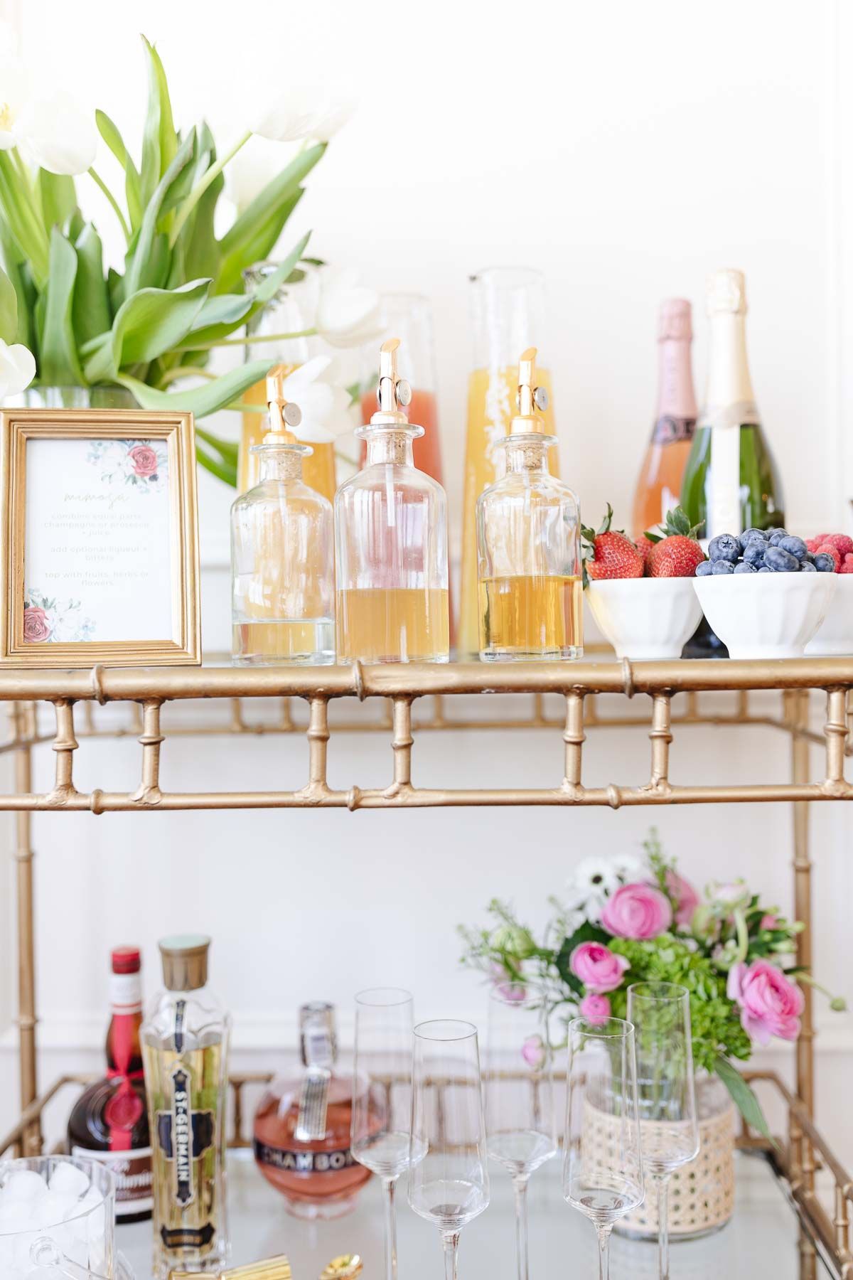 A mimosa bar set up on a gold bar cart