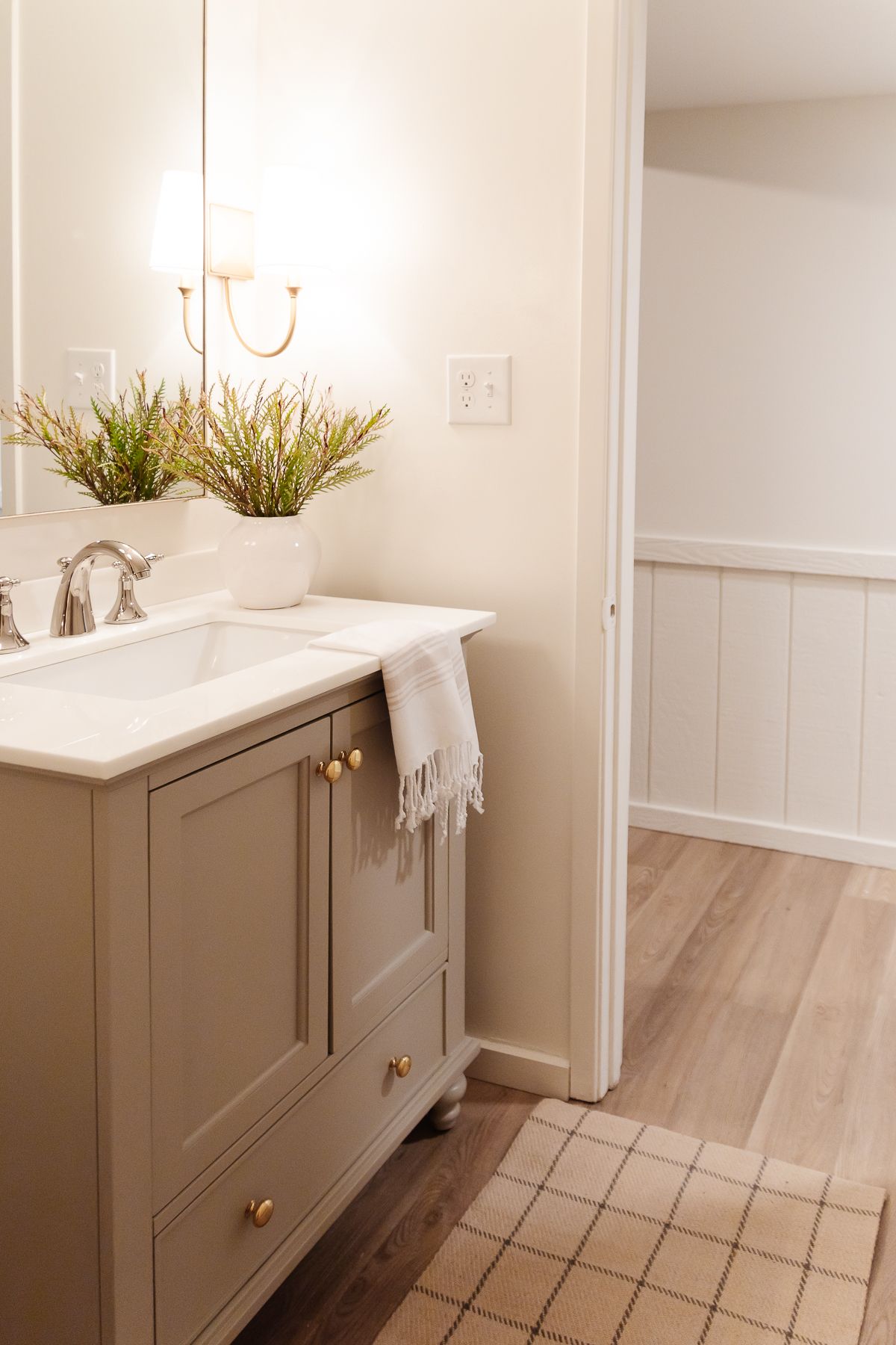 A cream bathroom with a vanity painted in a mushroom paint color