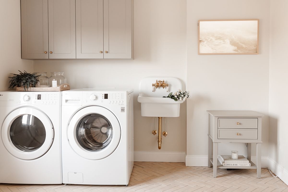 A laundry room with cabinets in a mushroom paint color