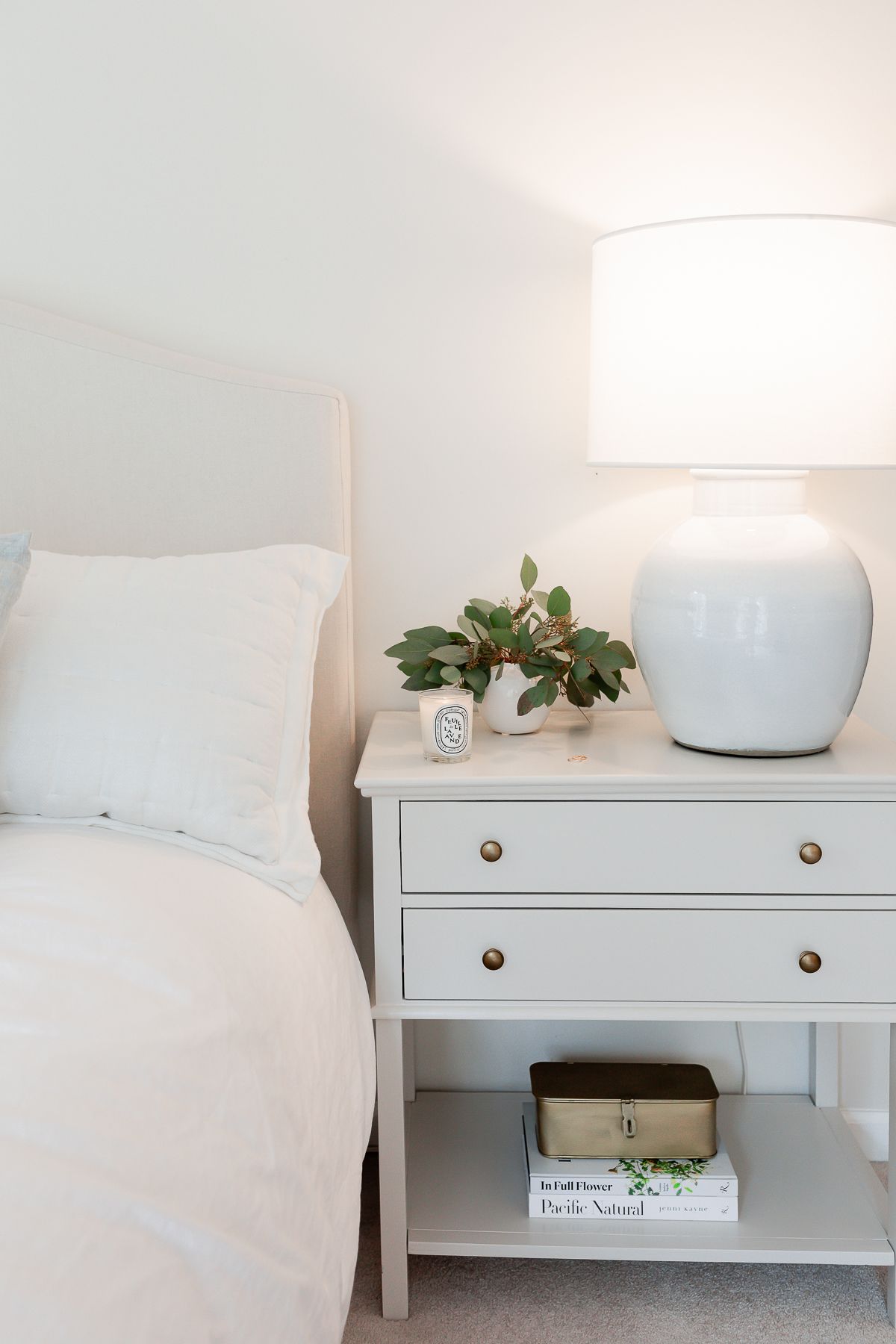 A bedroom with a bedside table painted in Benjamin Moore Pale Oak