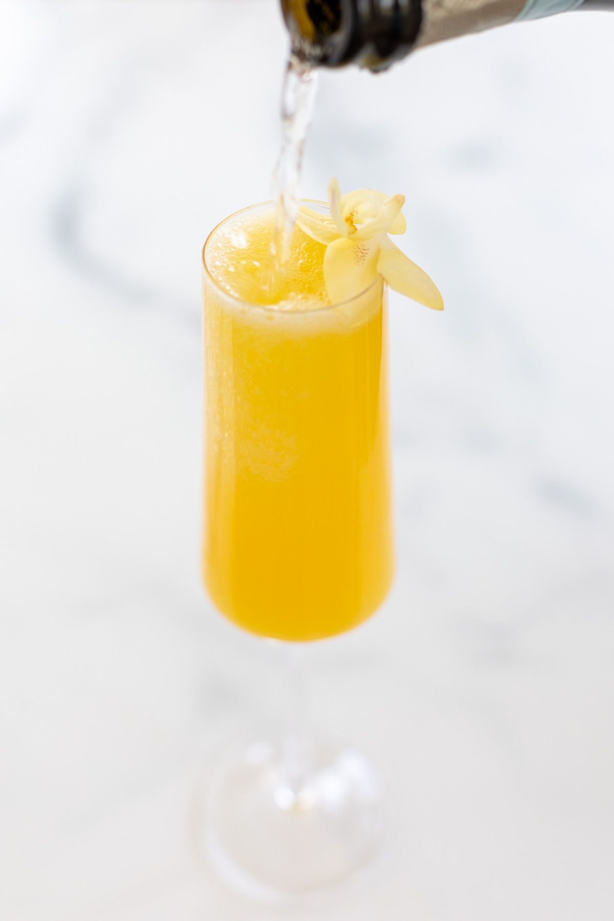 A prosecco mimosa garnished with a flower