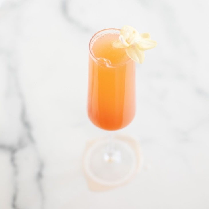 A grapefruit prosecco mimosa on a marble surface