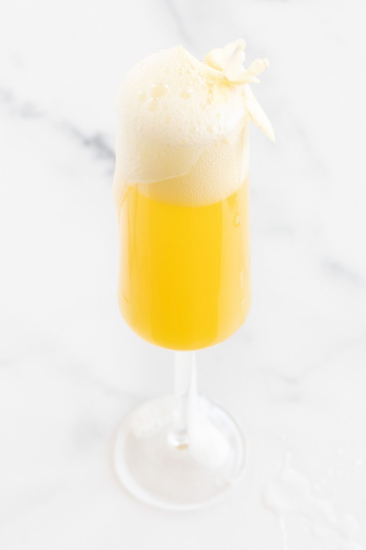 A prosecco mimosa garnished with a flower