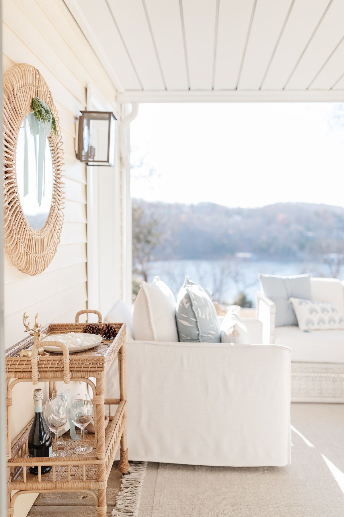 The outdoor patio is decorated with white tables and chairs and a rattan trolley