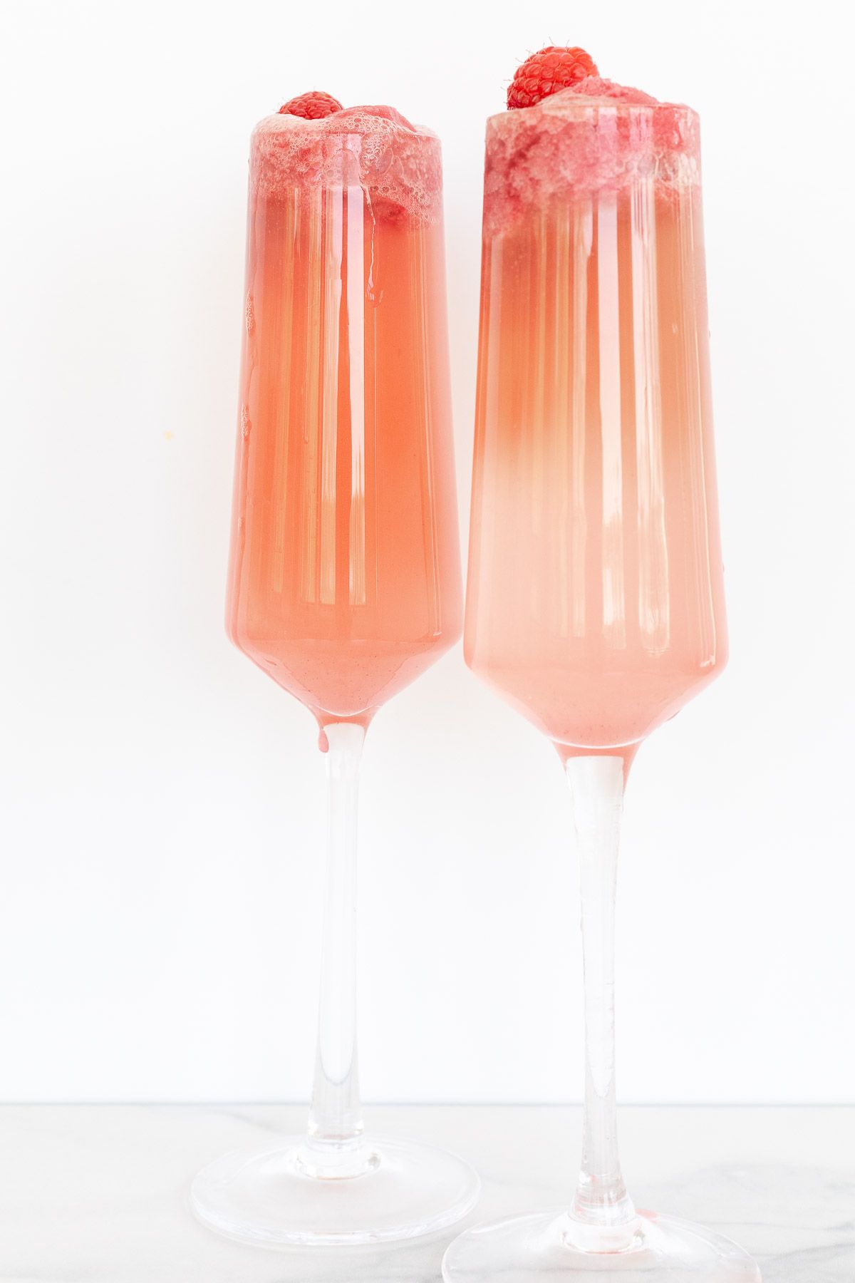 Two champagne flutes with sherbet mimosas