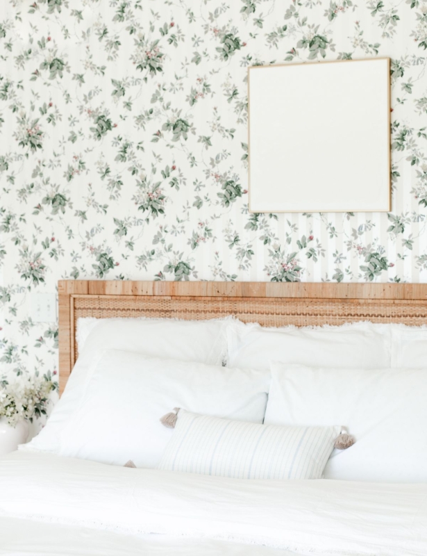 A wallpapered bedroom with white textured wall art over the bed
