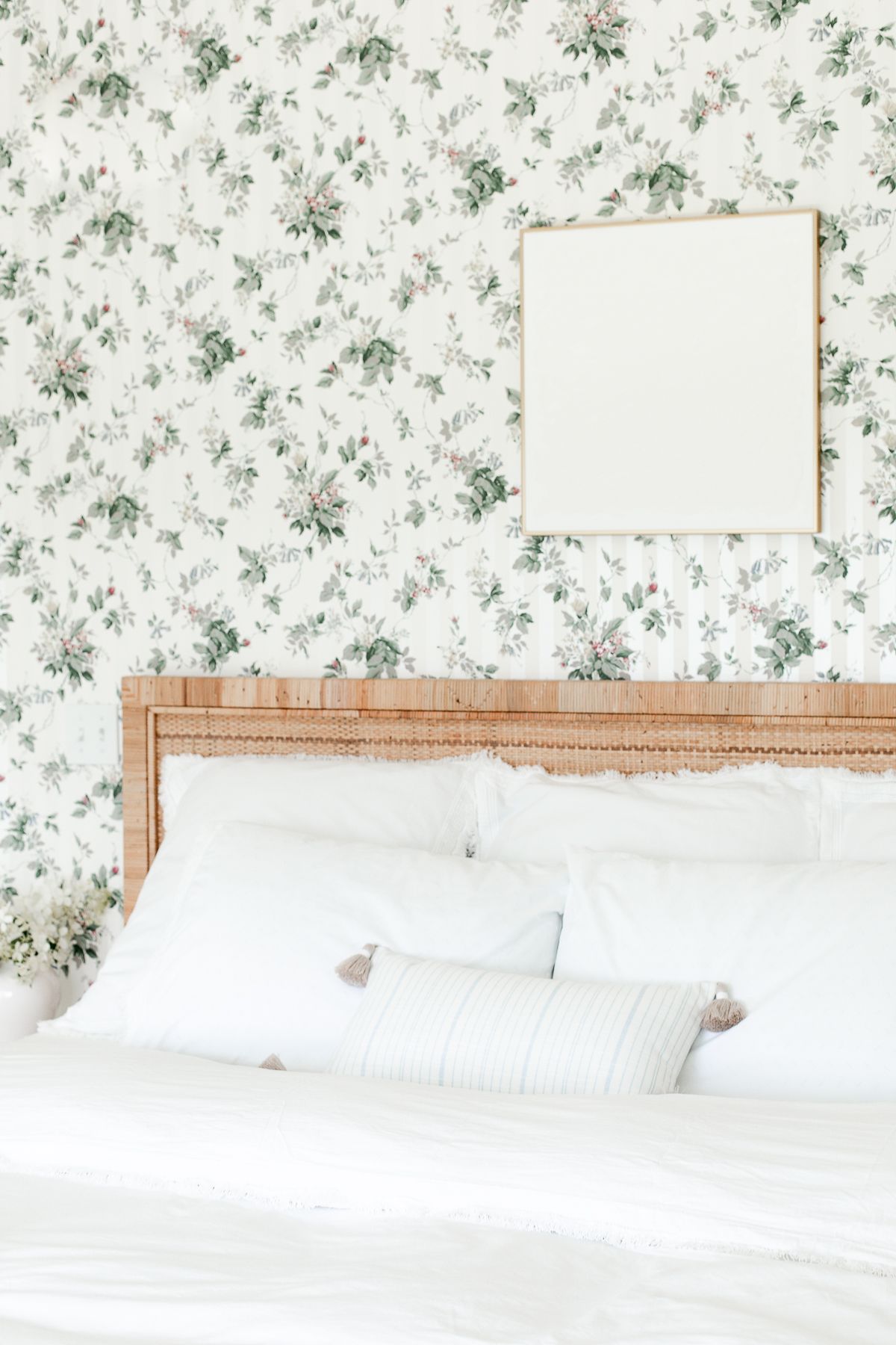 A wallpapered bedroom with white textured wall art over the bed