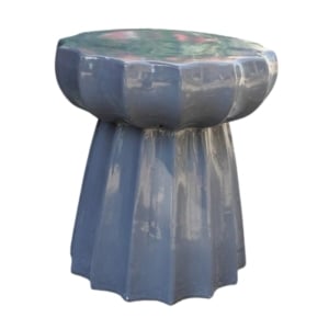 A blue ceramic table with a flower atop.
