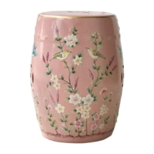 A pink ceramic garden stool adorned with flowers and birds.