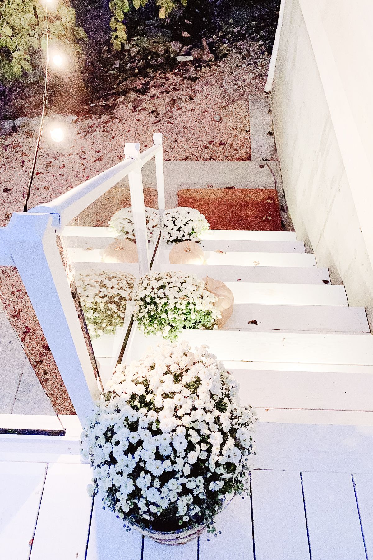 Stair lights and string lights on a white vinyl deck