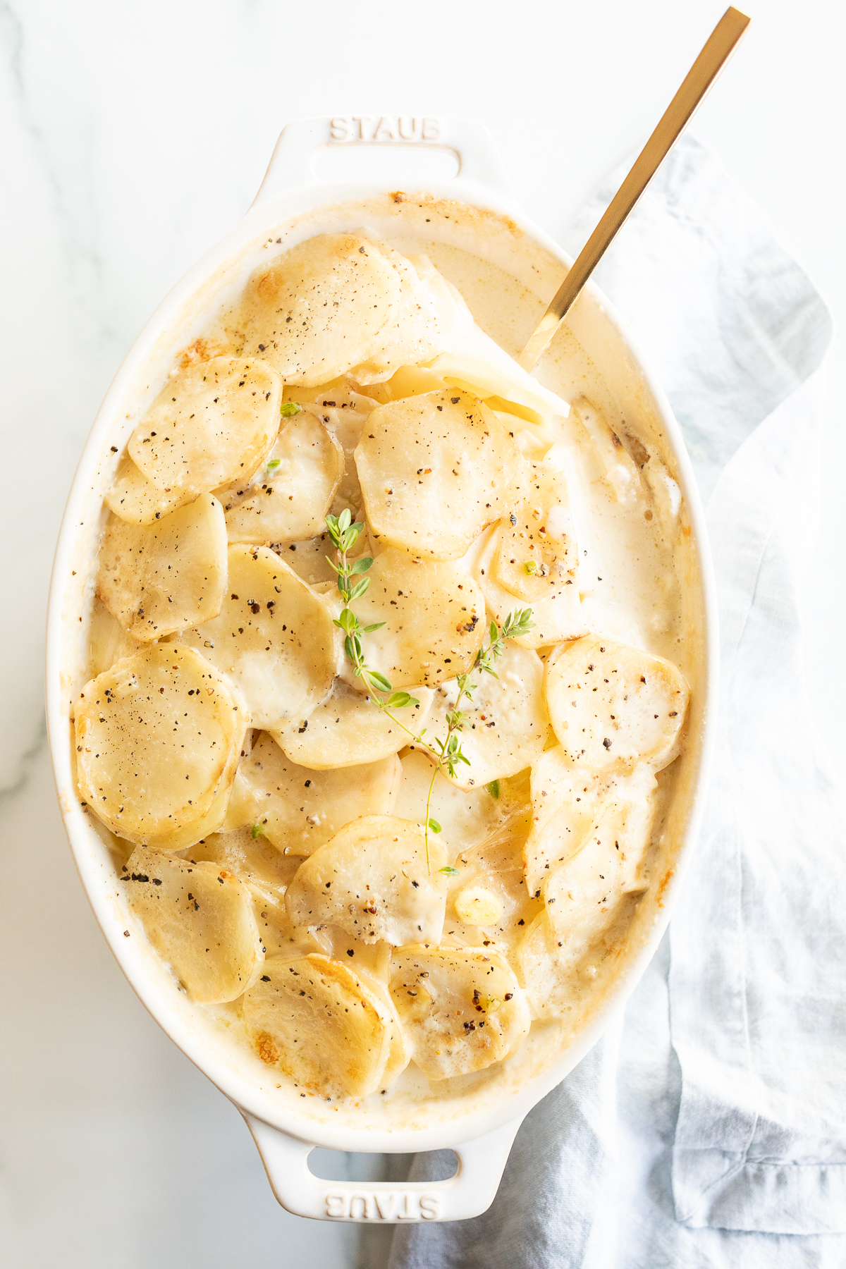 A flavorful potato side dish featuring thyme-dusted spuds served in a white dish.
