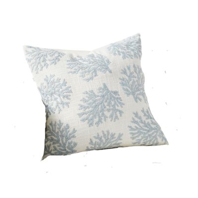 a blue and white pillow with a nautical coral design