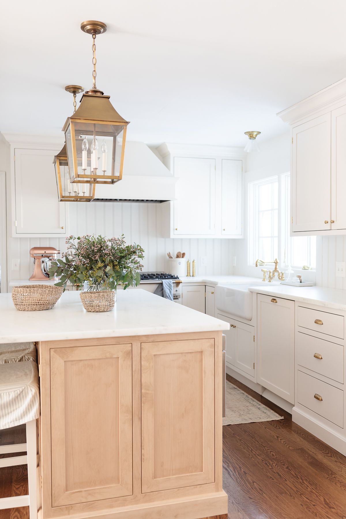 A light wood island with slipcovered kitchen island stools