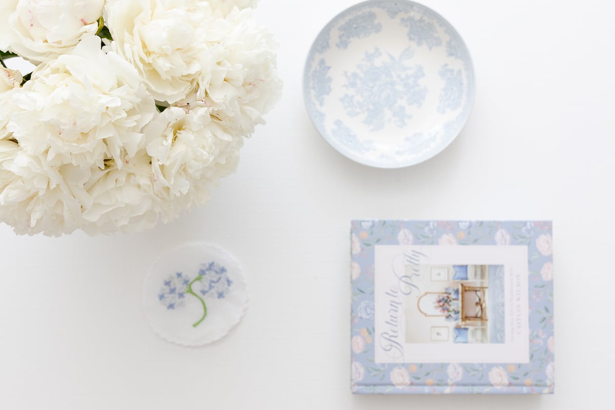 A white coffee table with soft blue and white coffee table decor.