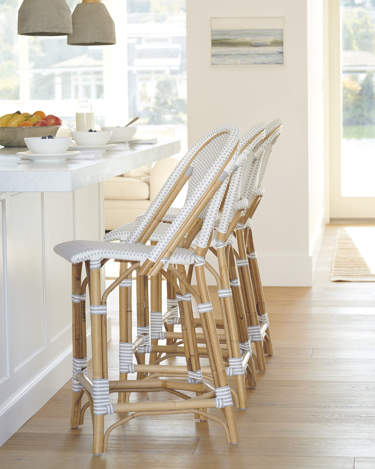 Bar stools in rattan at a white kitchen island