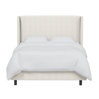 An upholstered bed with a white upholstered headboard.