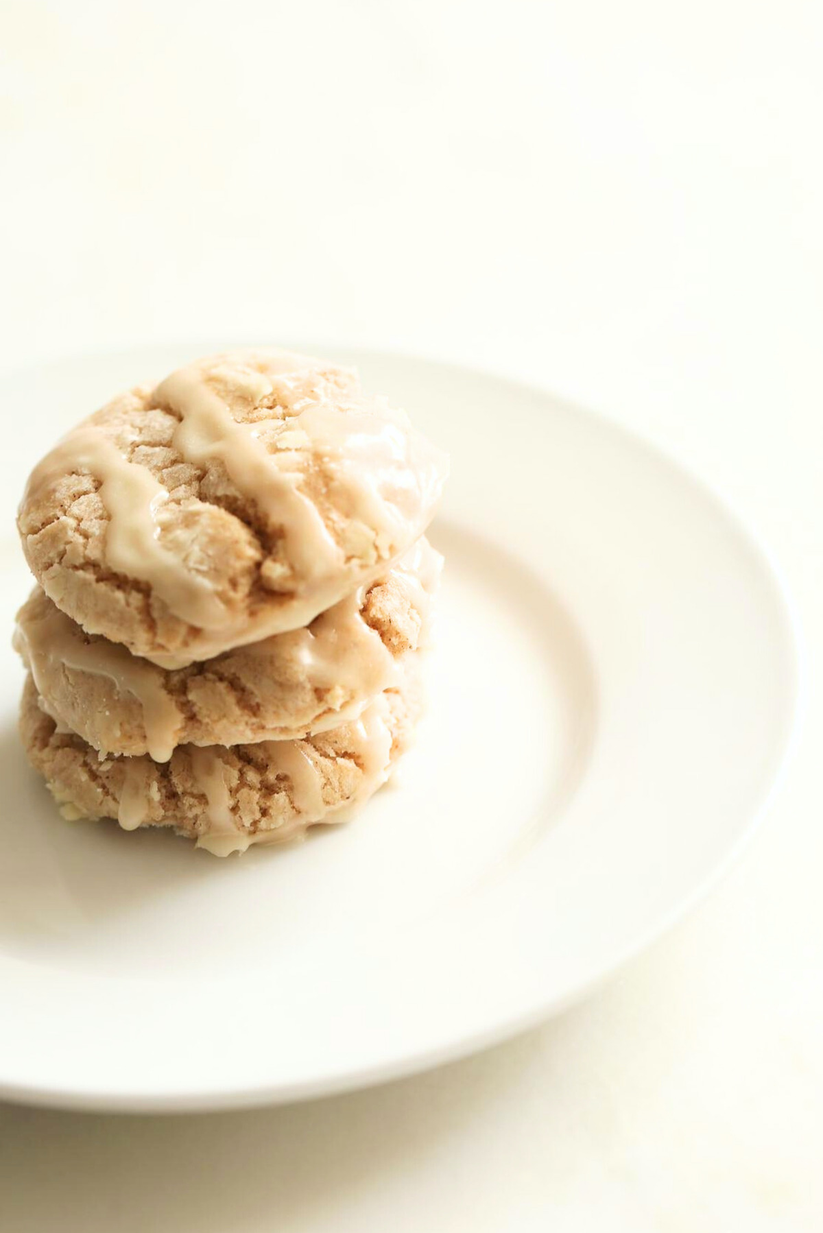 A stack of cookies on a white plate, perfect for indulging in apple recipes.