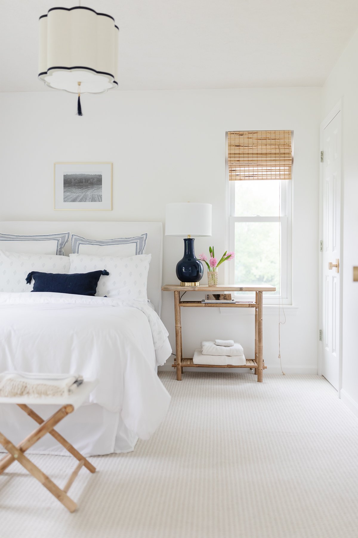 A white bedroom with neutral furnishings