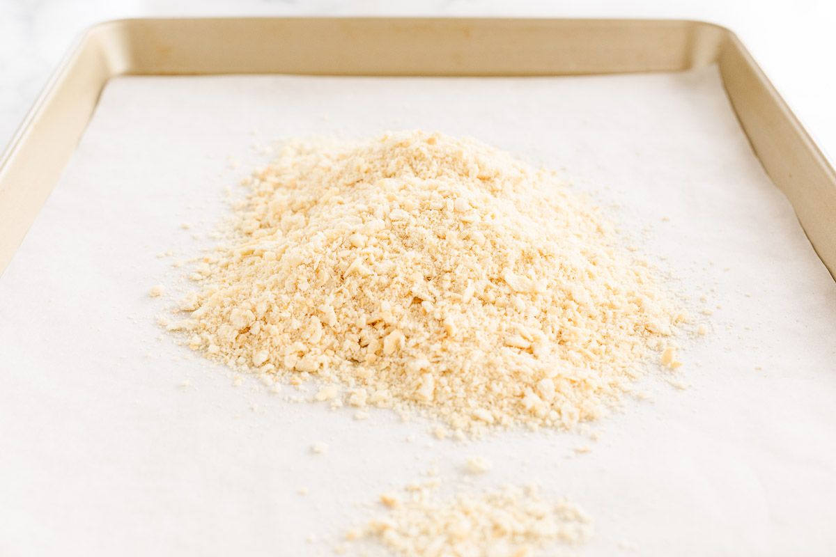 A pile of panko substitute crumbs on a gold baking sheet lined with parchment.