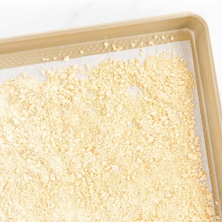 A panko substitute breadcrumb on a gold baking sheet lined with parchment paper